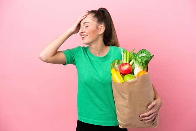 Mujer joven sosteniendo una bolsa de compras sonriendo mucho