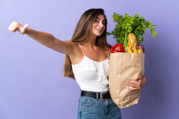 Mujer joven sosteniendo una bolsa de compras