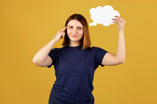 Foto mujer joven sosteniendo una burbuja de pensamiento