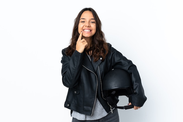 Foto mujer joven sosteniendo un casco de motocicleta sobre blanco aislado sonriendo con una expresión feliz y agradable