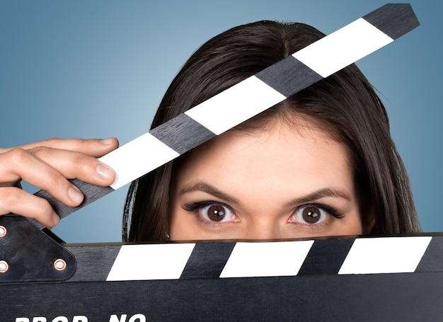 Foto mujer joven sosteniendo una claqueta de cine