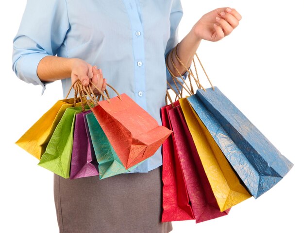 Mujer joven sosteniendo coloridas bolsas de compras en la mano aisladas en blanco