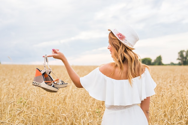 Mujer joven sosteniendo un concepto de consumismo y personas de venta de zapatos