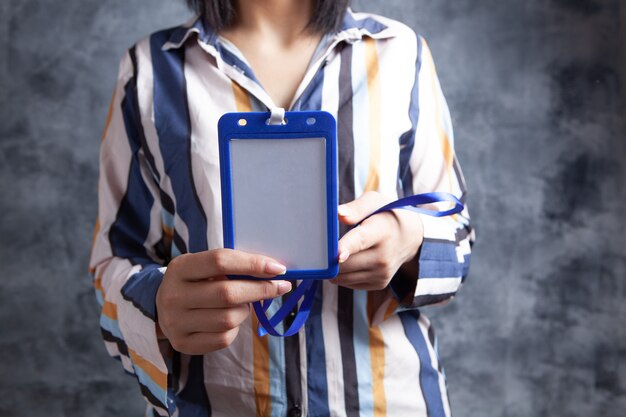 Mujer joven sosteniendo una etiqueta de identificación