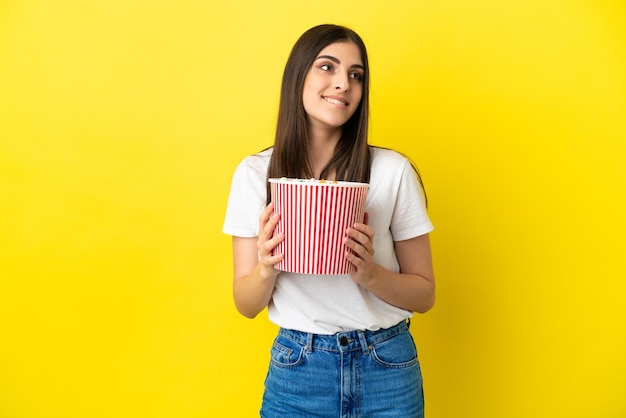 Mujer joven sosteniendo un gran balde de palomitas de maíz