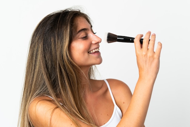 Mujer joven sosteniendo un pincel de maquillaje