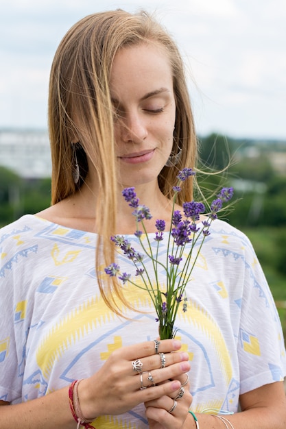 Mujer joven sosteniendo un ramo de lavanda