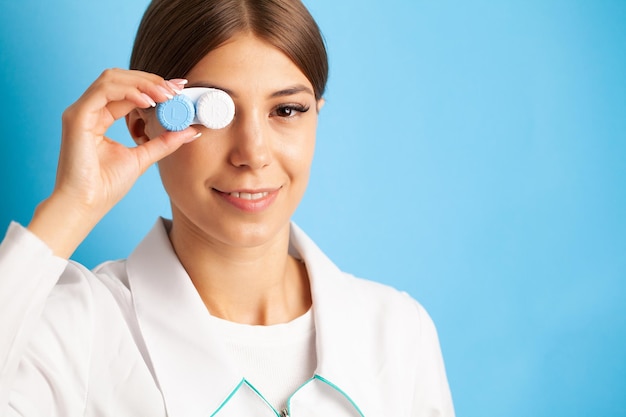 Mujer joven sosteniendo un recipiente blanco con lentes