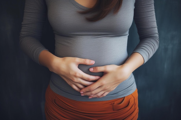 mujer joven sosteniendo su estómago con ambas manos concepto para la dismenorrea abdominal