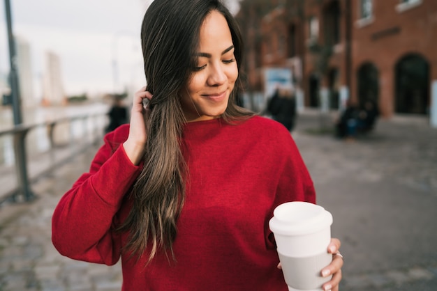 Mujer joven sosteniendo una taza de café.