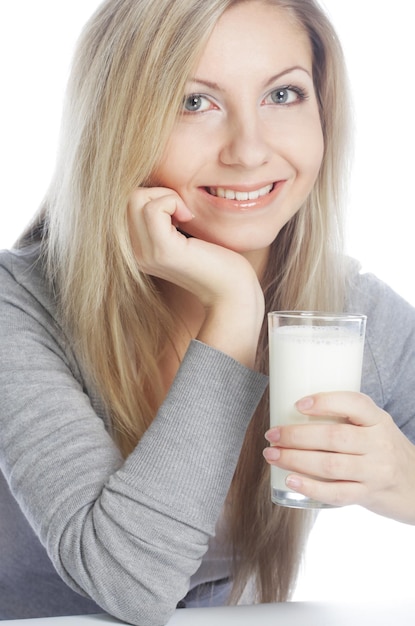 Mujer joven sosteniendo un vaso de leche fresca