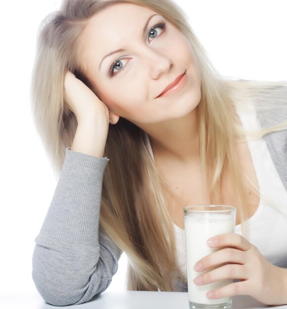 Mujer joven sosteniendo un vaso de leche fresca
