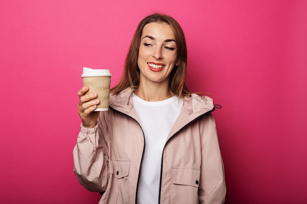 Mujer joven sosteniendo un vaso de papel mirándolo