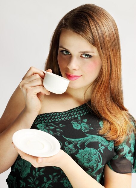 Foto mujer joven sostiene la taza con la bebida