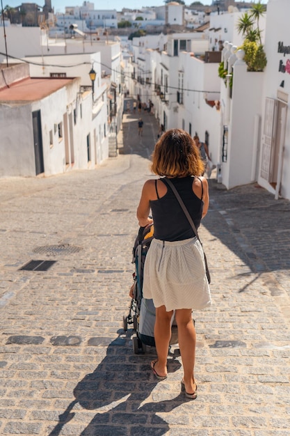 Una mujer joven con su bebé visitando la ciudad turística de vejer de la frontera cádiz andalucía