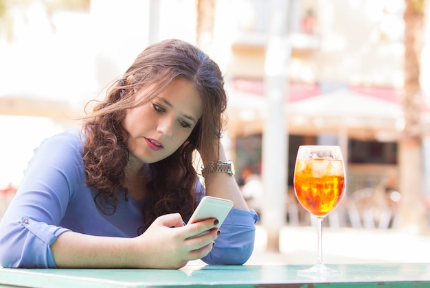 Mujer joven en su descanso leyendo un mensaje de texto en el móvil