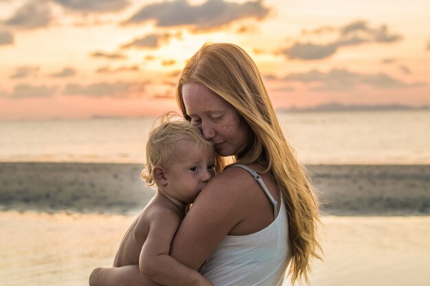 Mujer joven con su hijo en la playa