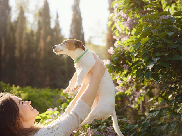 Mujer joven con su lindo Jack Russell Terrier al aire libre