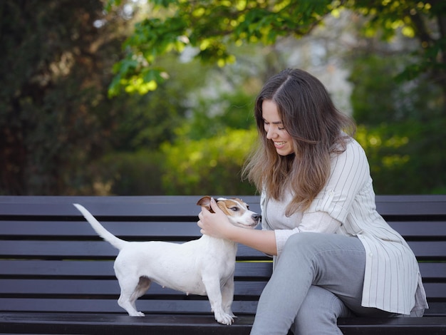 Mujer joven con su lindo Jack Russell Terrier al aire libre