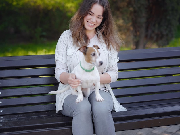 Mujer joven con su lindo Jack Russell Terrier al aire libre