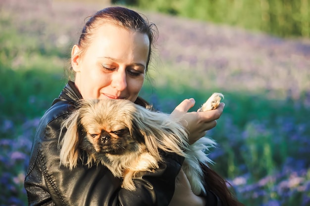 Mujer joven con su lindo perro al aire libre