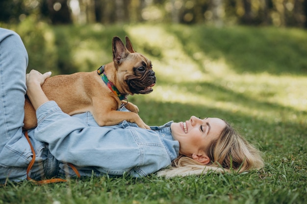 Mujer joven con su mascota bulldog francés en el parque