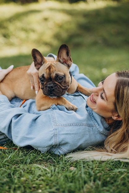 Mujer joven con su mascota bulldog francés en el parque