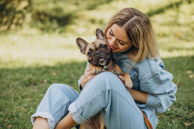 Foto mujer joven con su mascota bulldog francés en el parque