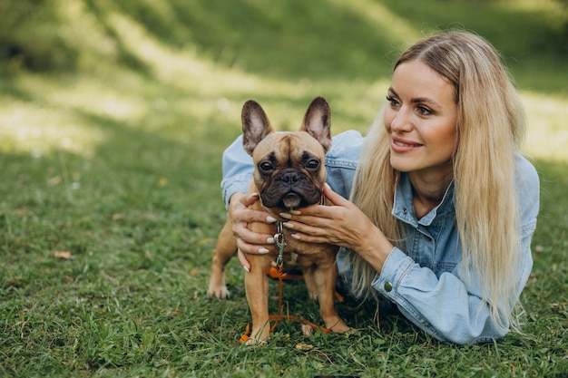 Mujer joven con su mascota bulldog francés en el parque