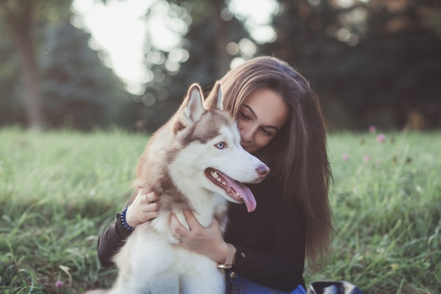 Mujer joven y su perro husky