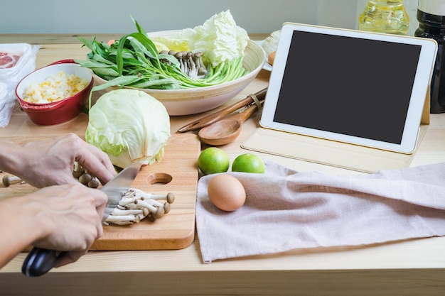 Mujer joven con su touchpad en la cocina