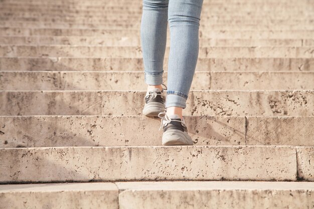 Mujer joven subiendo las escaleras en la ciudad.