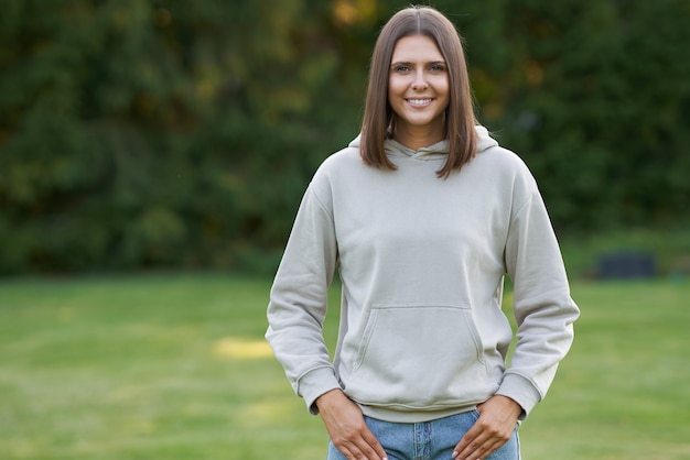 Mujer joven en sudadera con capucha beige. Foto de alta calidad