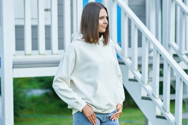 Mujer joven en sudadera con capucha blanca. Foto de alta calidad