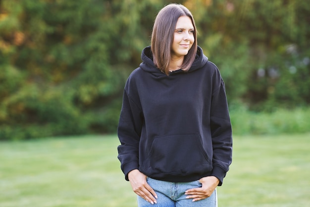 Mujer joven en sudadera con capucha negra. Foto de alta calidad