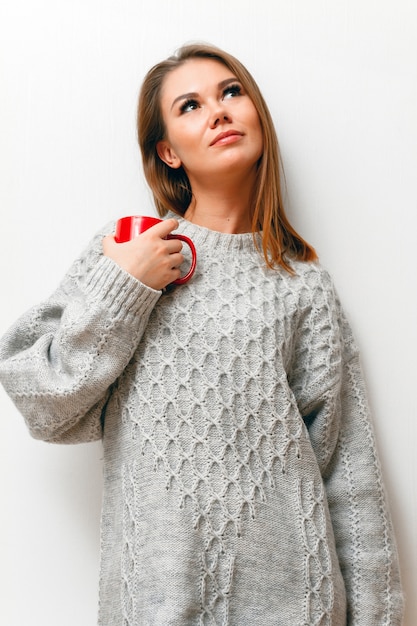 Mujer joven en un suéter de punto blanco
