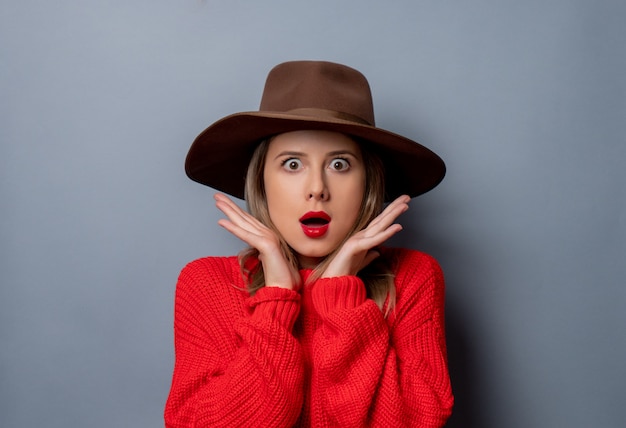 mujer joven en suéter rojo y sombrero