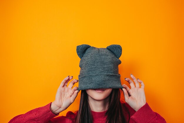 Mujer joven en suéter y sombrero con orejas. Ropa de invierno. Sombrero en la cara.