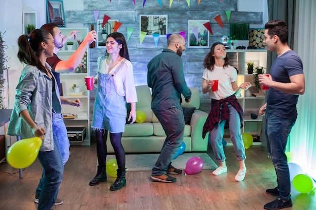 Mujer joven y sus amigos en una fiesta. Gente disfrutando de buena música.