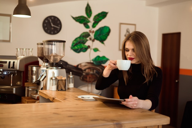 Mujer joven con tablet PC en un café.