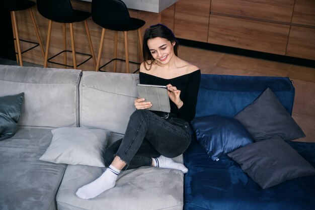 Mujer joven con tablet pc en el sofá