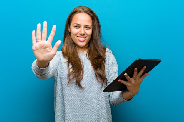 Mujer joven con una tableta en azul