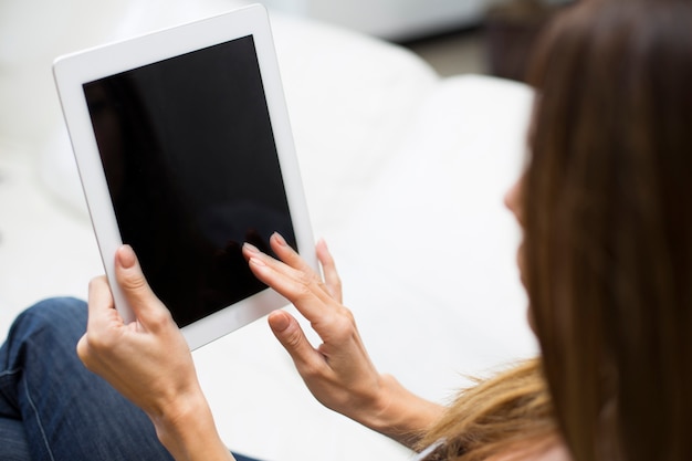 Mujer joven con tableta en casa