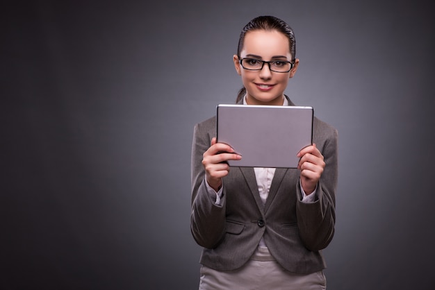 Mujer joven con la tableta en concepto del negocio