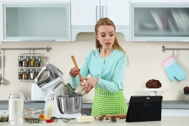 Mujer joven con una tableta para seguir una receta