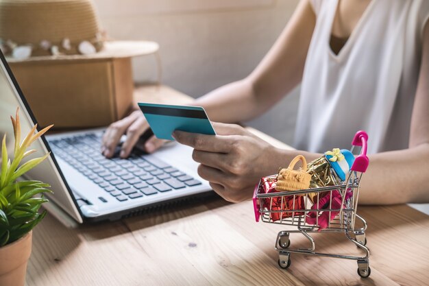 Mujer joven con tarjeta de crédito e ingresa el código de seguridad para el pago, compras en línea en casa