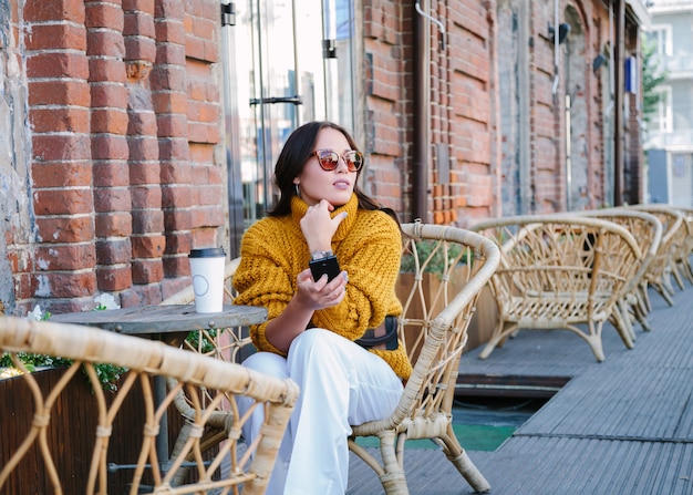 Mujer joven con una taza de café al aire libre