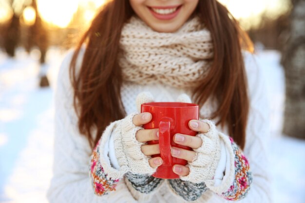 Mujer joven, con, taza de café caliente, aire libre, en, invierno, día, primer plano