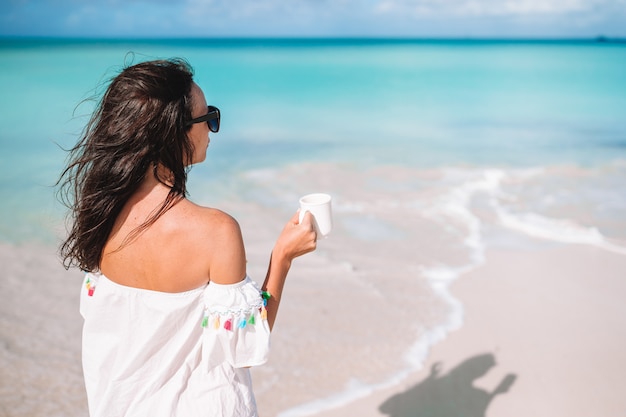 Mujer joven con una taza de café caliente disfrutar de vacaciones