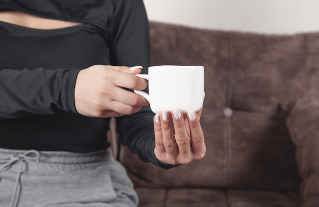 Mujer joven con una taza de café en casa.